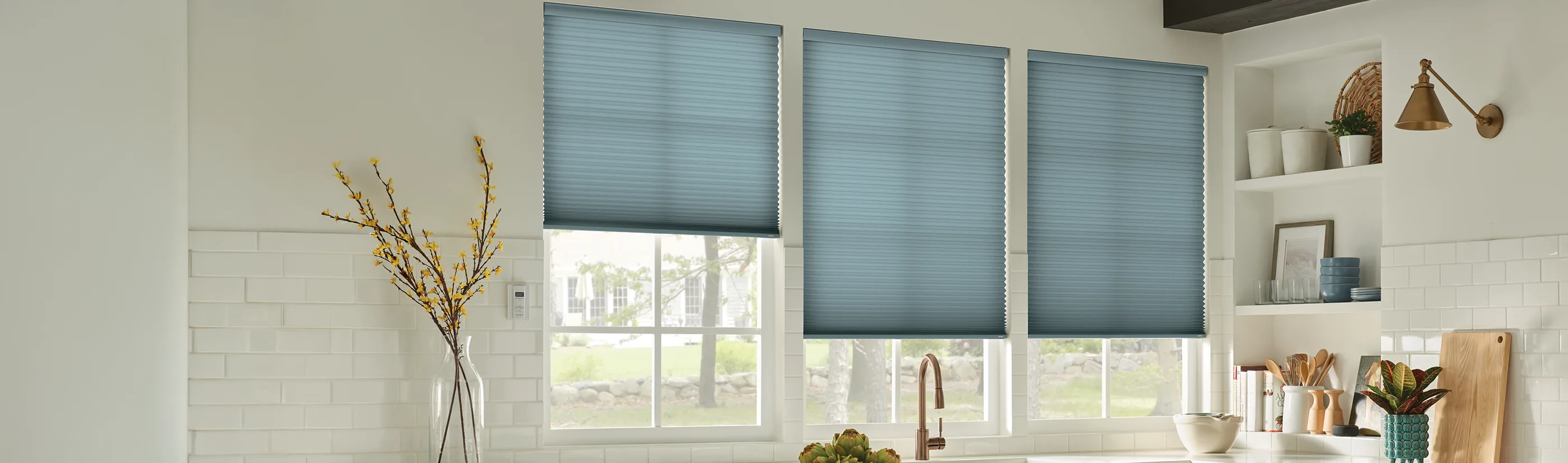 teal green cellular shades in three tall windows above a kitchen sink