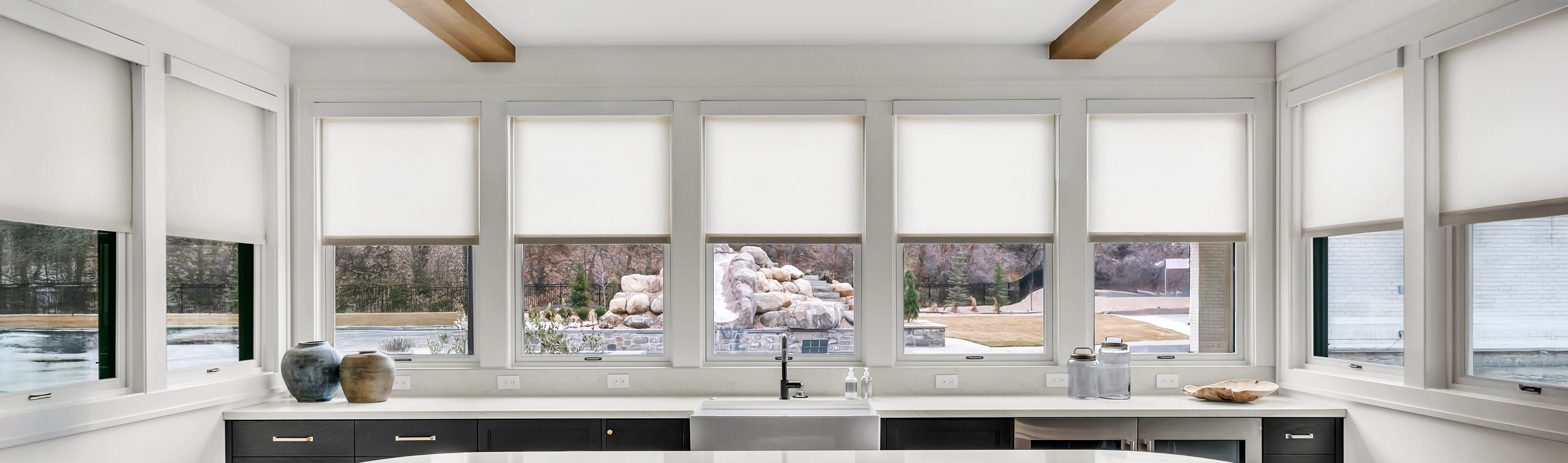 white roller shades on lots of windows with a panoramic view from the kitchen to the backyard