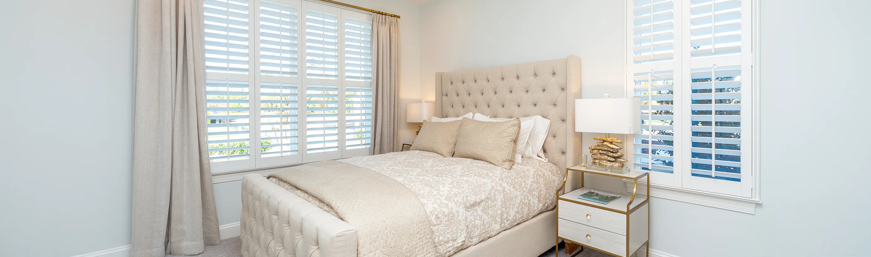 white polywood shutters in a bedroom with beige bedding and curtains