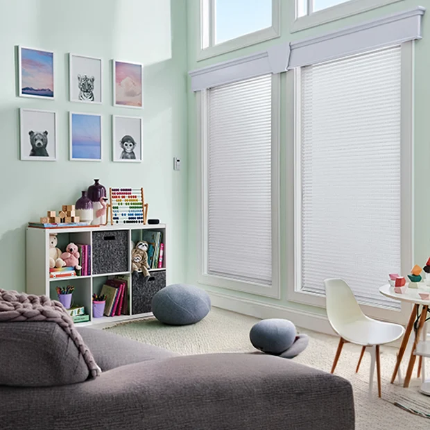 White sheer shades within a kids' playroom with mint color walls and toys