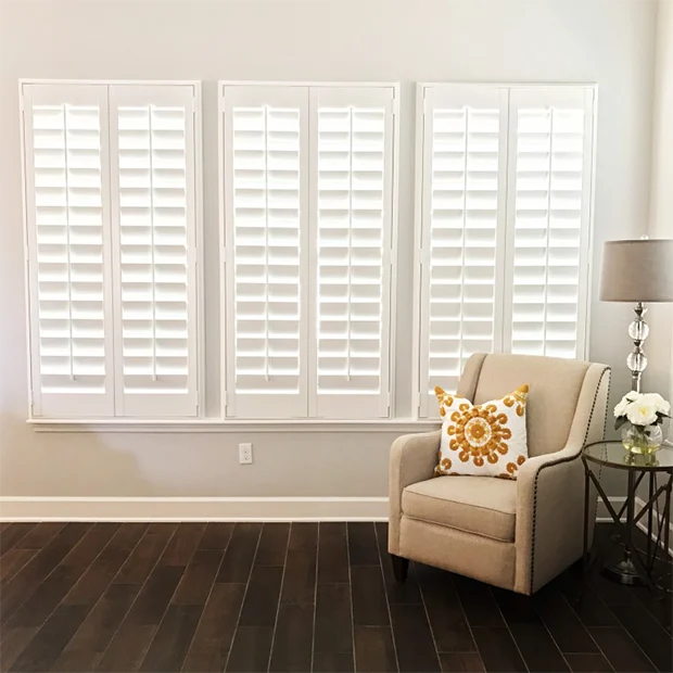 white shutter windows in a corner of a living room area