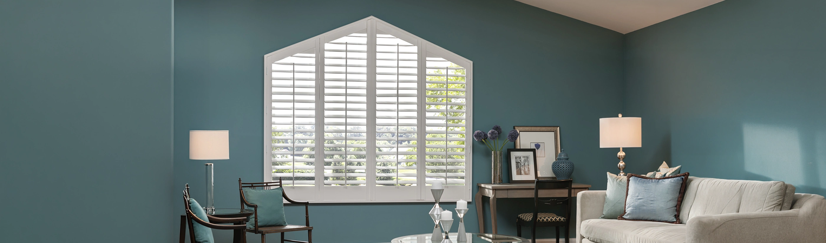 white polywood shutters rake window shape in a dark sea green living room