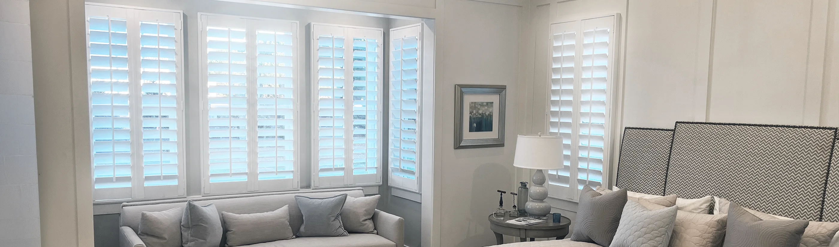 white studio shutters in a bay seat window inside a large bedroom