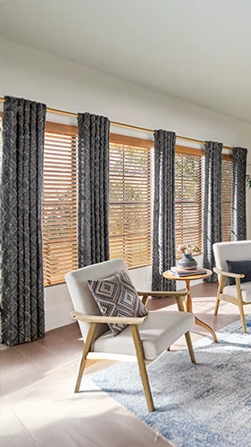 Blue draperies over wooden blinds on large living room windows