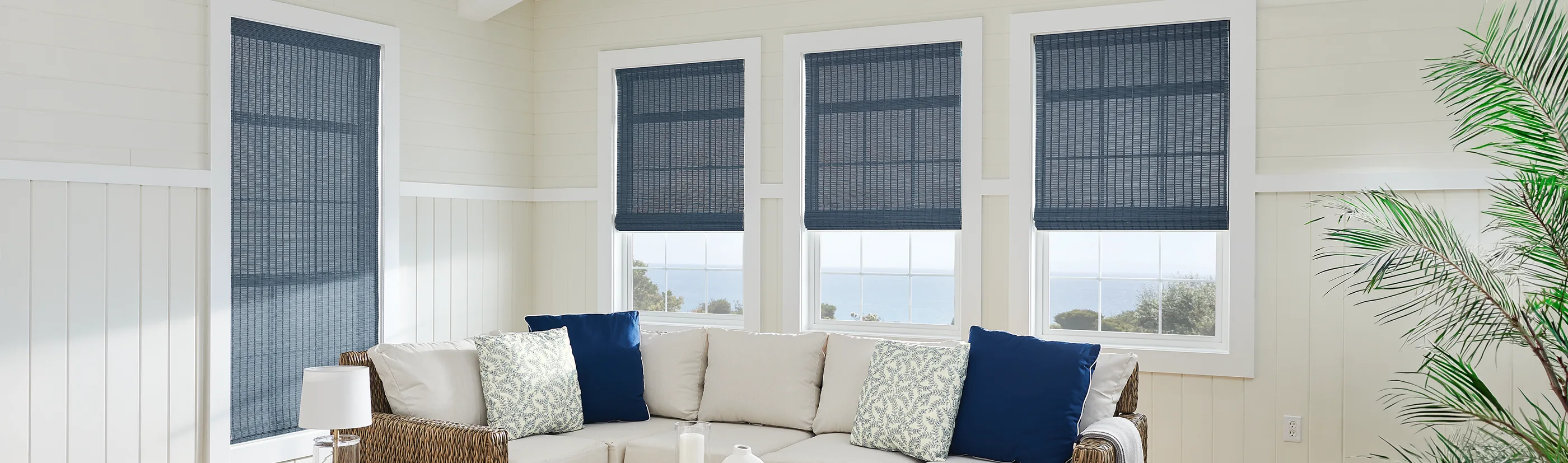 slate blue woven shades on four windows in a beach house living room