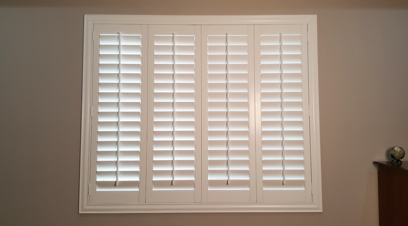 Custom window treatments have a clean fit and a more sophisticated look. Interior custom shutters in a bedroom
