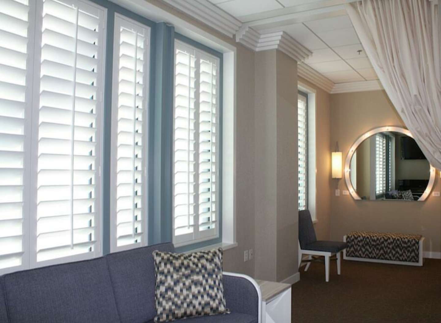 Plantation shutters in hallway with circular mirror