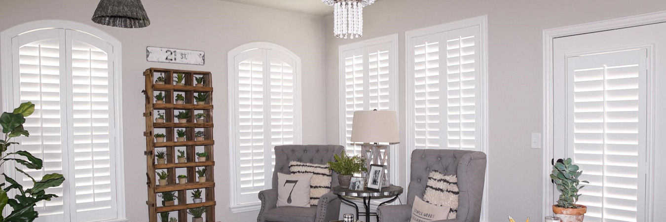 White Polywood shutters on several windows in a stylish living room