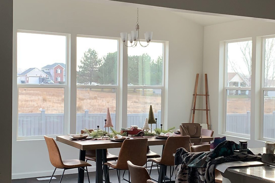 A dining room with bare windows.