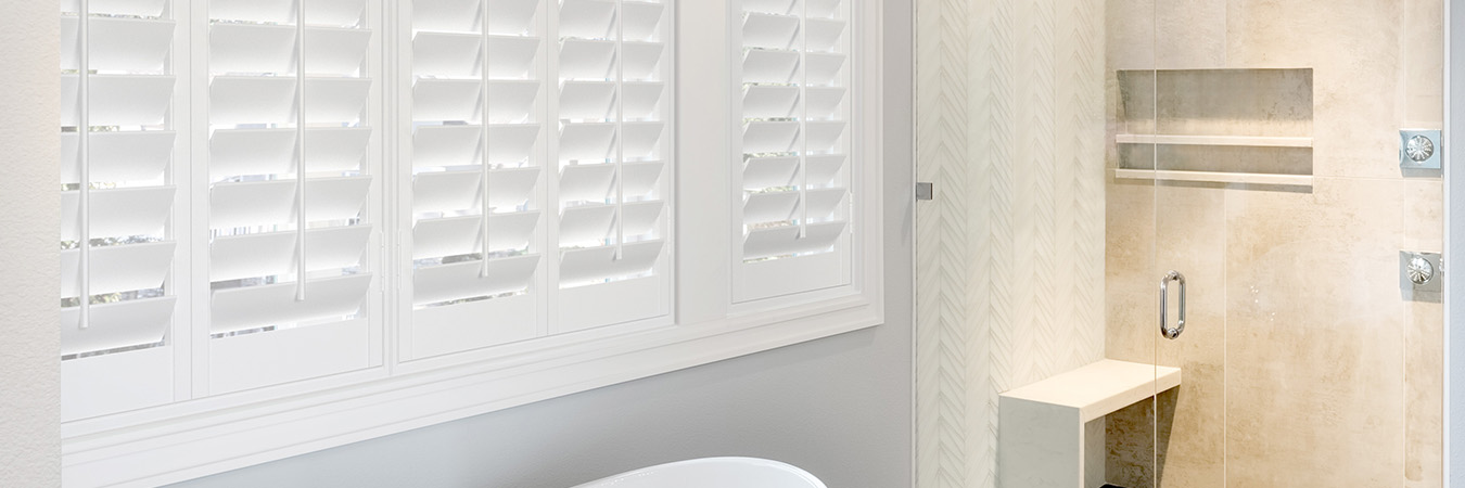 plantation shutters over a small bathtub