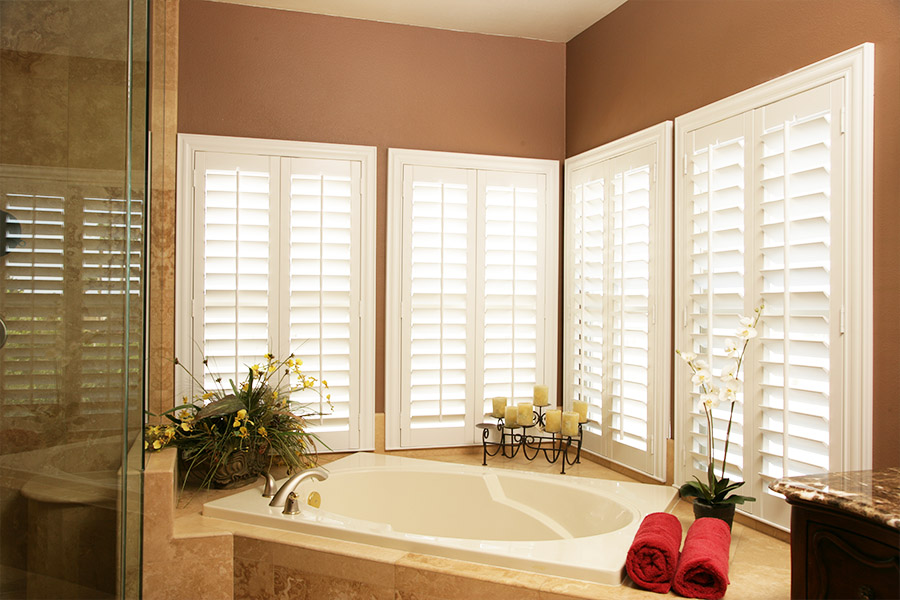 White Polywood shutters above a bathtub