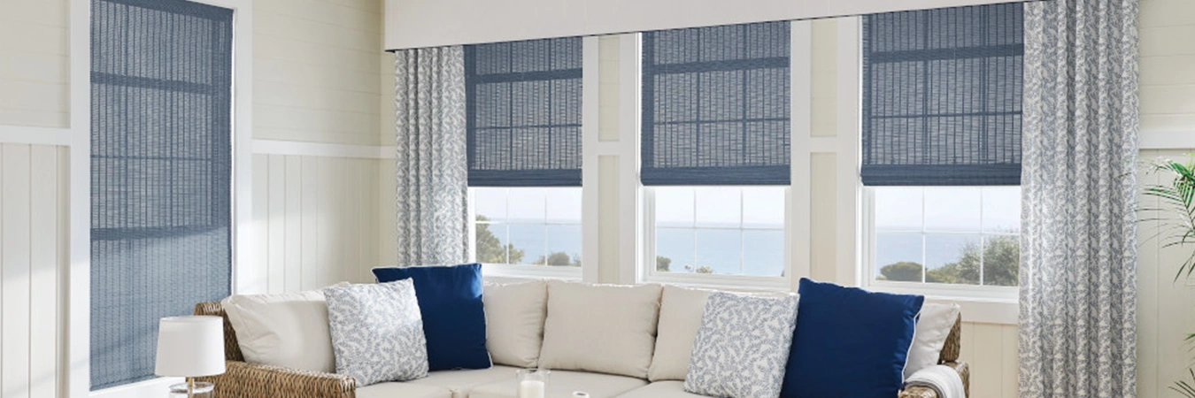 Blue and white patterned drapes with blue shades on living room windows.