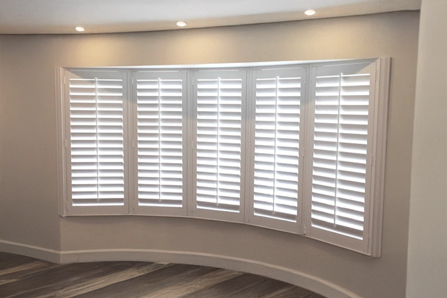 With so many windows in a row, keep your home protected from outside temperatures with insulating Polywood shutters on your bow windows.