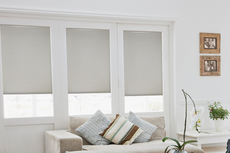 Light gray cellular shades in a white and off white living room.