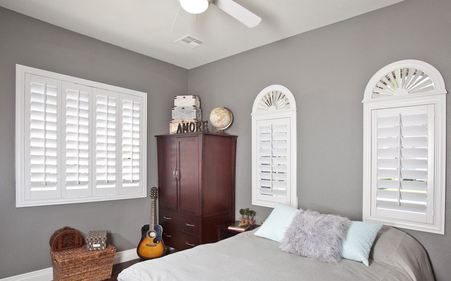 White arched shutters in a bedroom.
