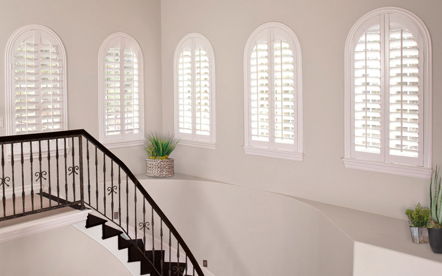 White arched windows near a stairwell.
