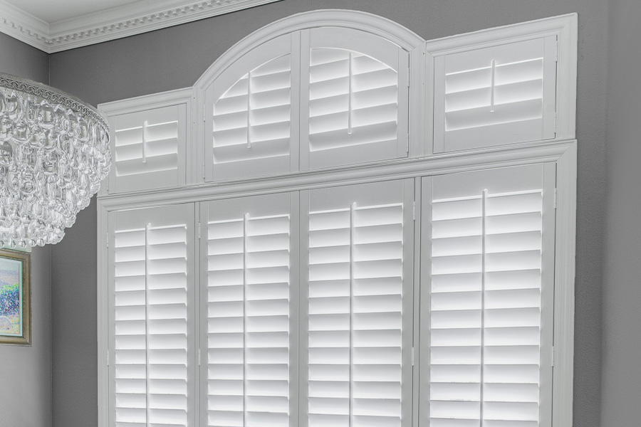 White Polywood shutters with front-facing tilt rods in a dining room.