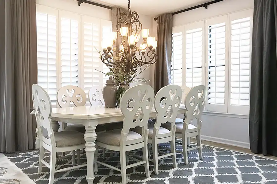White Polywood shutters with wide louvers on dining room windows