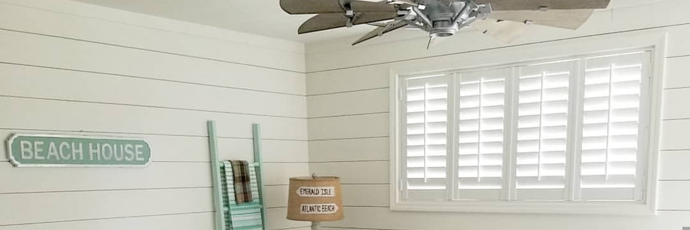 White polywood shutters on a basement level window.