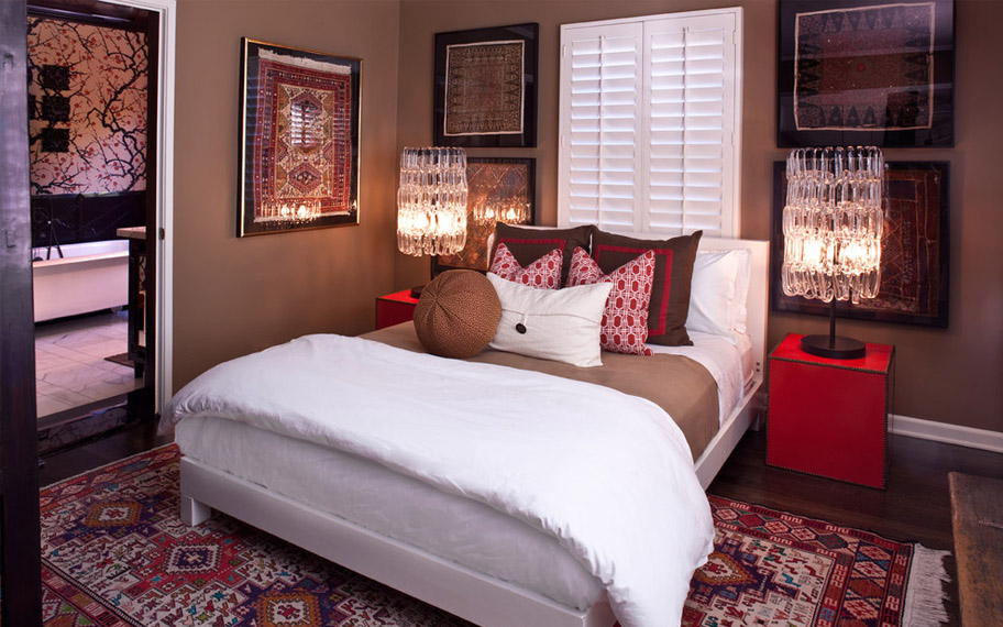 Your guests will get a good night of sleep in a comfortable bed. Photo Credit: Elizabeth Gordan White shutters in a black and red bedroom.