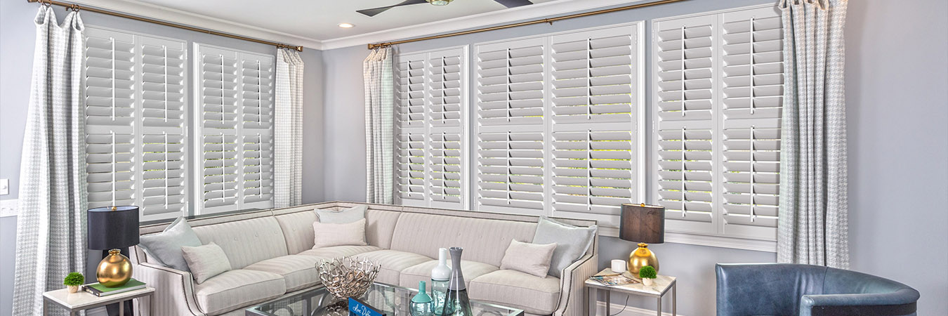 White polywood shutters in a large living room.