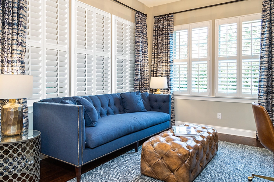 If you want more color on your windows, consider layering colored drapes with your interior shutters. Blue patterned drapery with white Polywood shutters