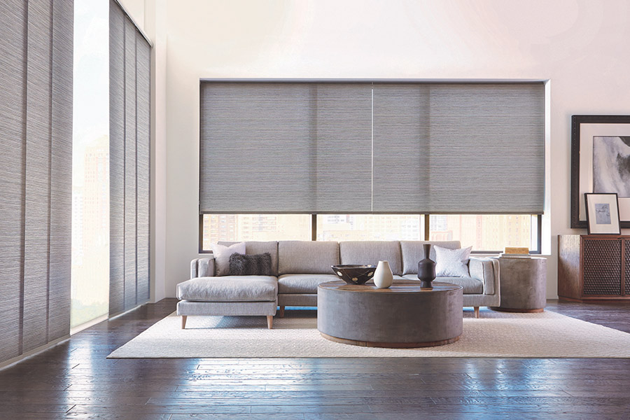 Battery-powered automatic window shades make it a cinch to operate large or out-of-reach window shades. Gray window shades on large living room windows
