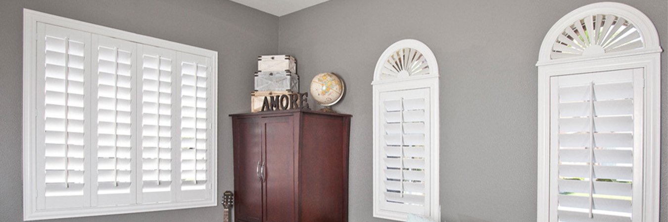 White arched shutters in a bedroom.