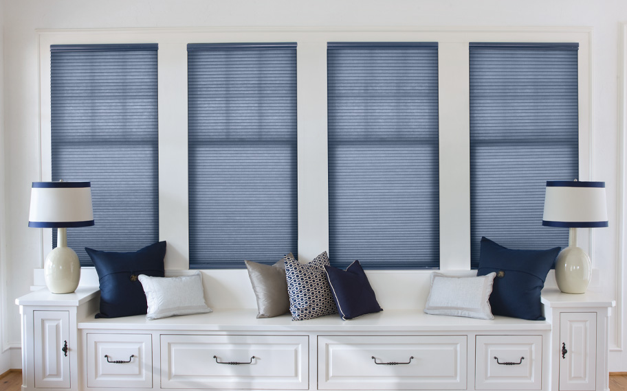 Blue cellular shades by a window seat