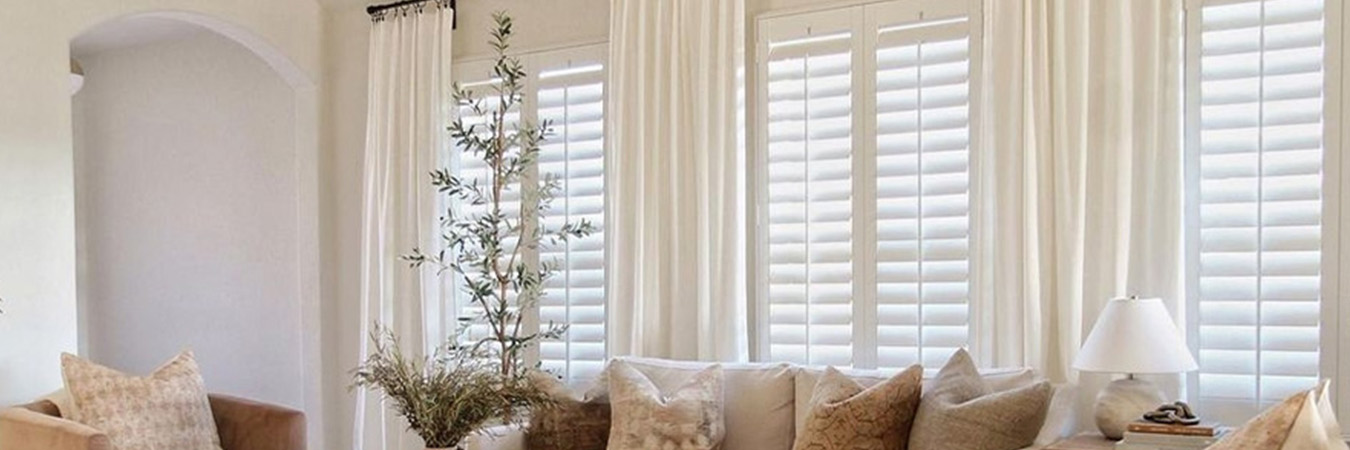 White polywood shutters in a large living room.