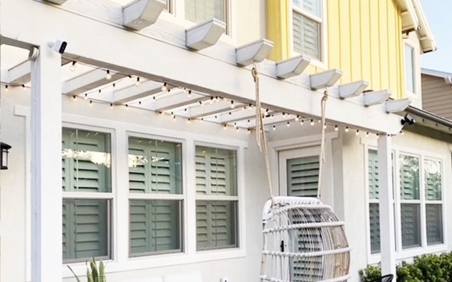 Energy-efficient windows work with Polywood shutters to insulate your home. Exterior shot of windows on a yellow house.