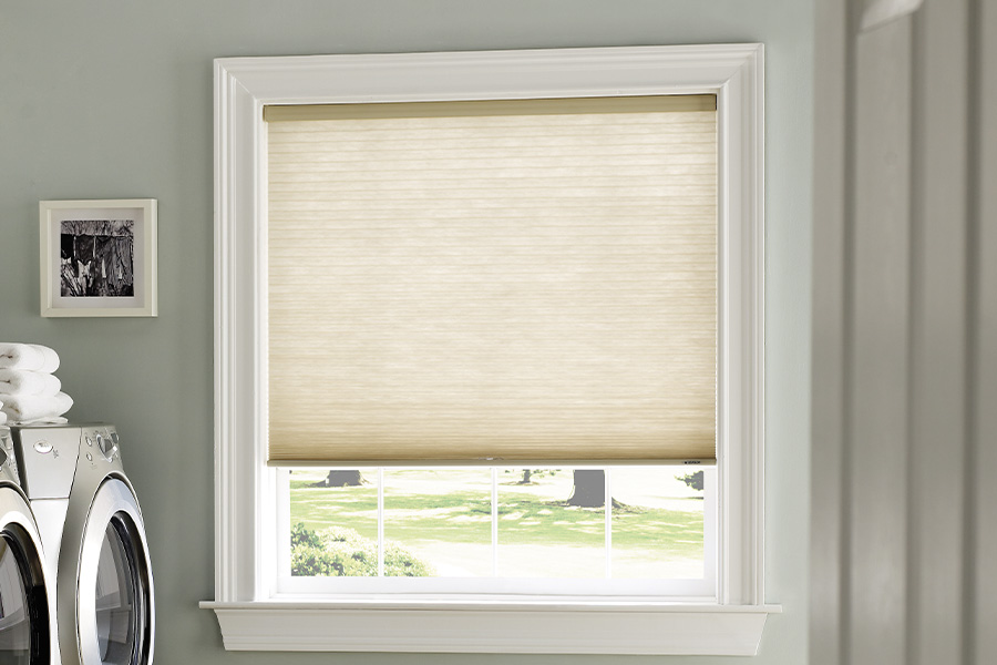 Beige roller shade within a mudroom