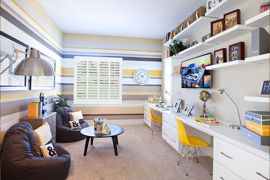 Blue and yellow playroom/work room with white polywood shutters.