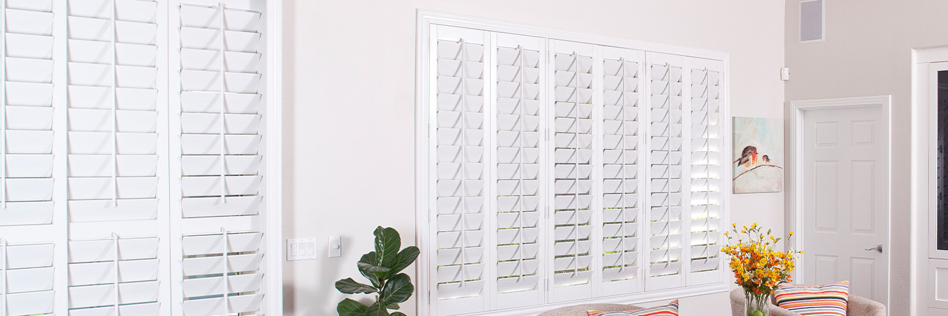 White Polywood shutters in a large modern living room.