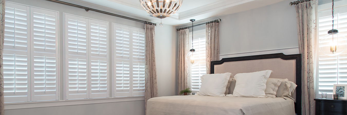 bedroom with large white Polywood shutter windows.