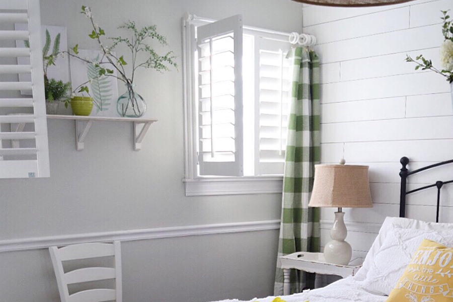 White bedroom with white polywood shutters that opens and closes.