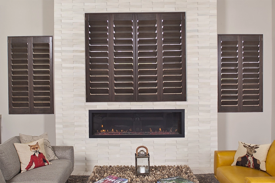 Save yourself the stress of sanding and repainting your lovely wood shutters and seek other alternatives. Dark wood interior shutters in a living room