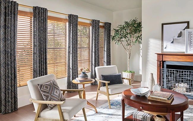 Patterned slate blue draperies overlaying wood blinds in a large living room