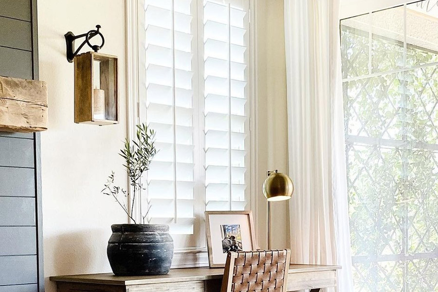 Corner of a small office next to a small white Polywood shutter window.