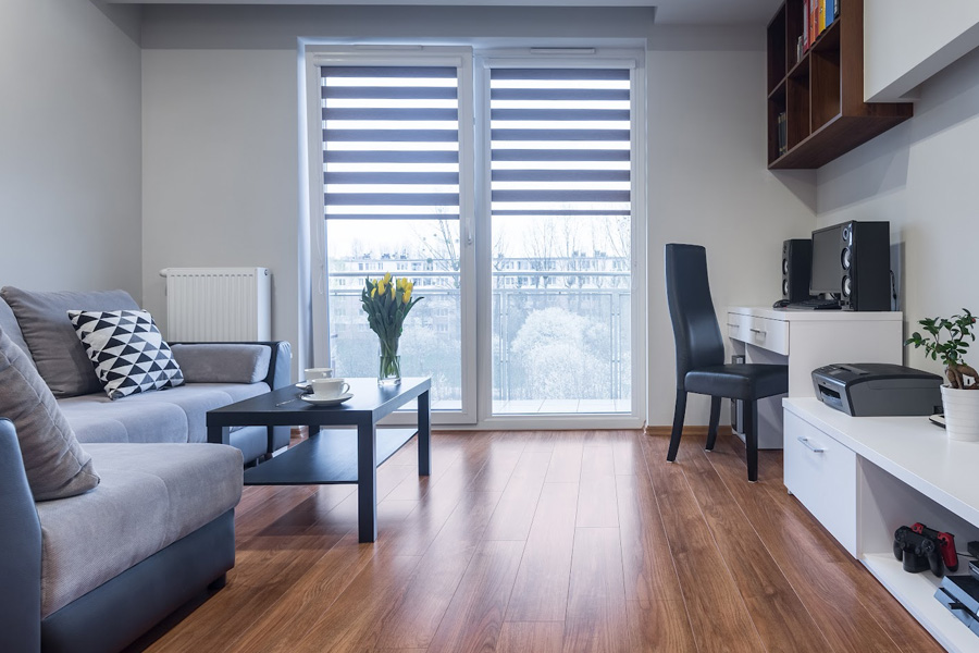 Light pours through windows partially covered by sheer roller shades.