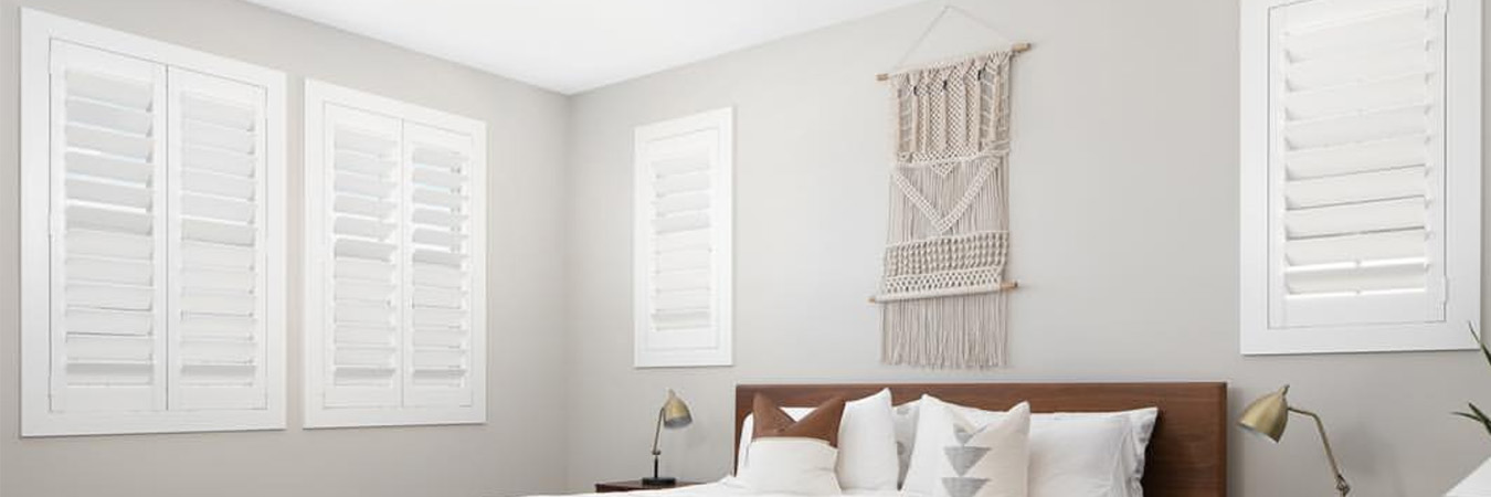 White Plantation shutters in a large bedroom.