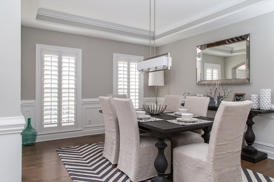 Let the sunshine in with white Polywood interior shutters within your dining room. Spacious dining room with two large Polywood shutter windows.