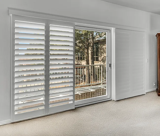 White shutter sliding Doors with an outdoor view of a deck and trees