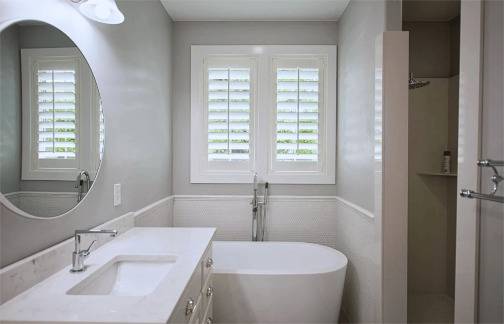 Adding a bathroom or other room to your home might earn you tax deductions when you sell the house later. White moisture-resistant polywood shutters in a bathroom