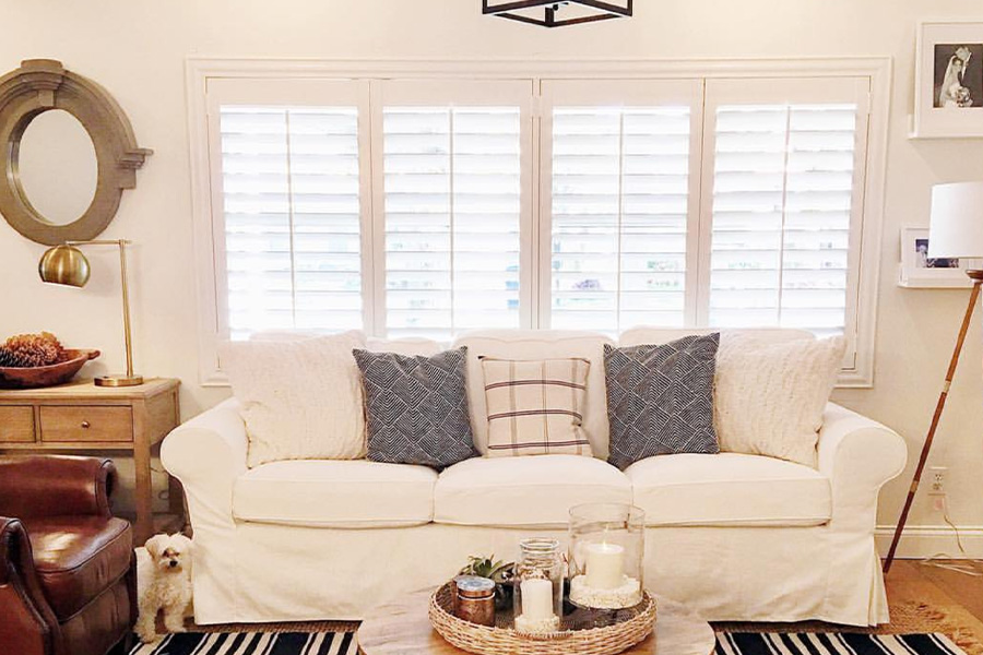 Stylish light fixtures and open Polywood shutters in a living room