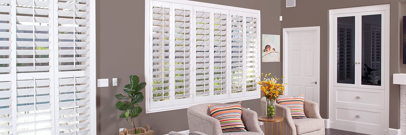 White Polywood interior shutters on a living room window and patio door