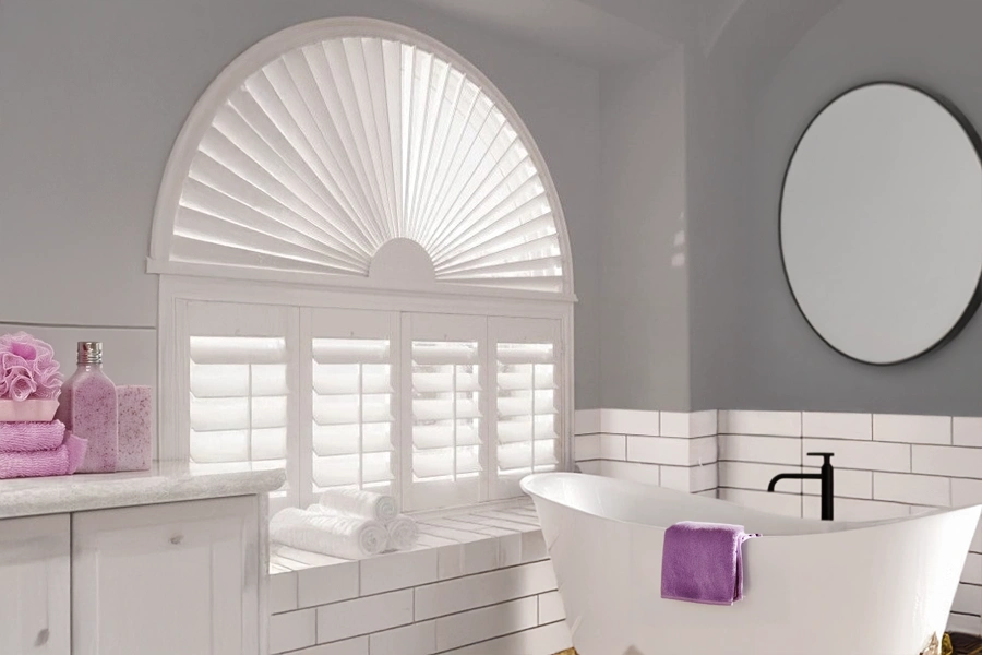 White Polywood shutters and sunburst shutter on an arched bathroom window