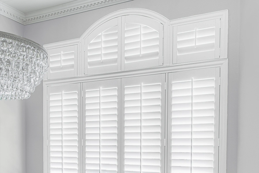 White Polywood shutters on a Palladian window in a white dining room