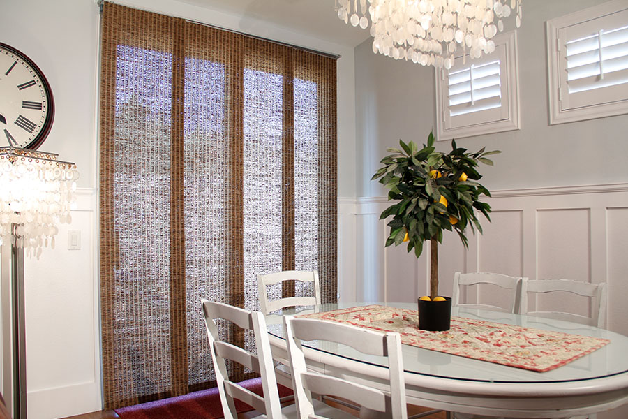 Elegant woven fiber window shades dress up your windows and dining room. Woven fiber window shades in a white formal dining room.