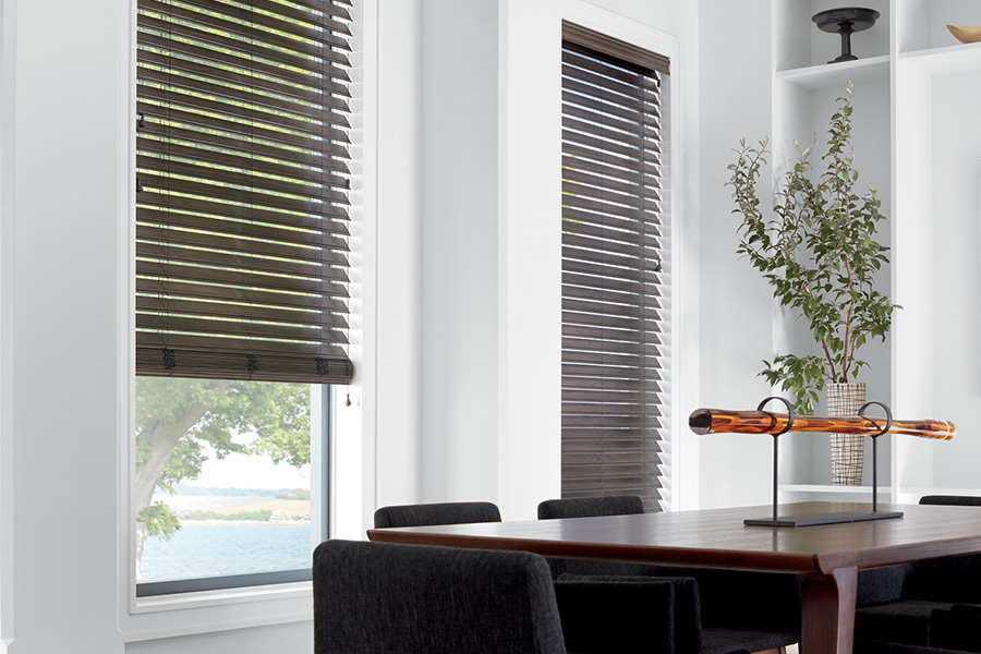 Faux wood blinds give you the right amount of privacy and natural light. Dark faux wood blinds in three windows. A large dining room with modern decor.